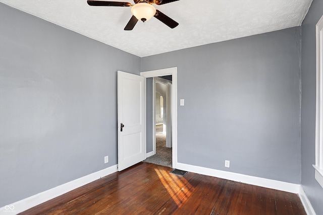 spare room with ceiling fan, a textured ceiling, and dark hardwood / wood-style flooring