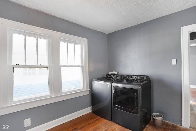 washroom featuring dark wood-type flooring, separate washer and dryer, and a textured ceiling