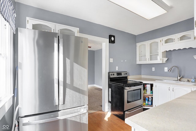 kitchen featuring white cabinetry, sink, stainless steel appliances, and light hardwood / wood-style floors