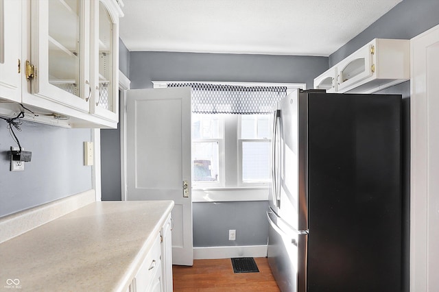 kitchen featuring white cabinetry, stainless steel fridge, dark wood-type flooring, and a textured ceiling