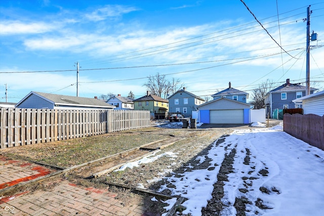 snowy yard with an outbuilding and a garage