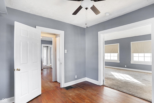 empty room featuring dark hardwood / wood-style floors, a textured ceiling, and ceiling fan