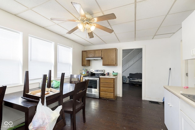 interior space with a paneled ceiling, sink, ceiling fan, dark wood-type flooring, and electric stove