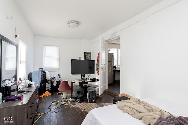 bedroom featuring dark wood-type flooring and stainless steel fridge