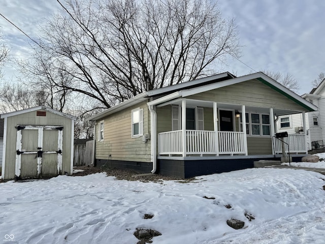 view of front of home with a porch and a storage shed