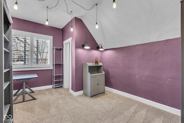 interior space with vaulted ceiling and light carpet