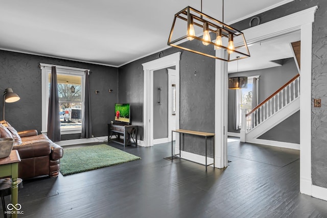 living room with crown molding, dark hardwood / wood-style floors, and a chandelier