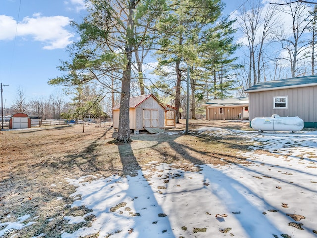 yard covered in snow with a storage shed