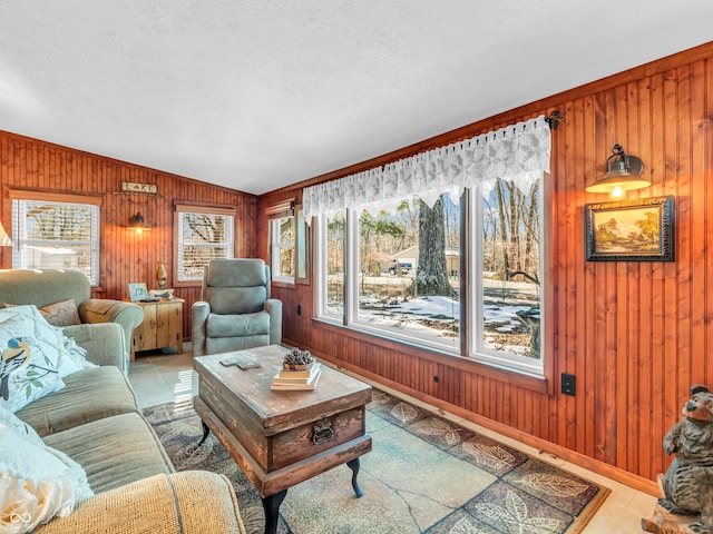 living room featuring a textured ceiling and wood walls