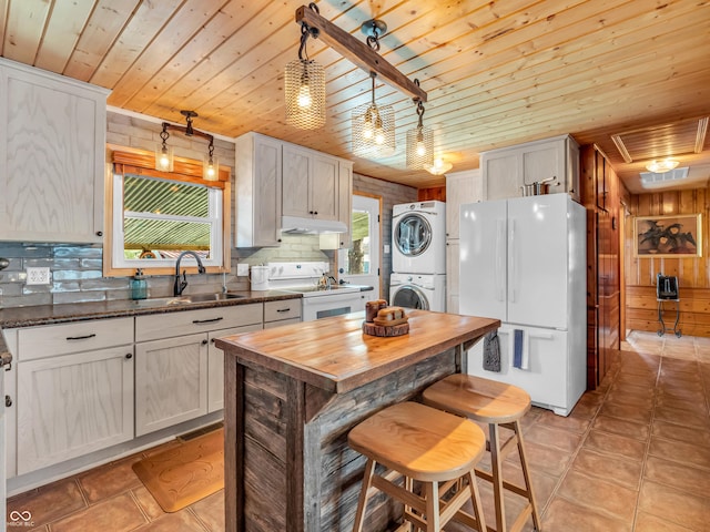 kitchen with tasteful backsplash, sink, stacked washer / drying machine, wood ceiling, and white appliances