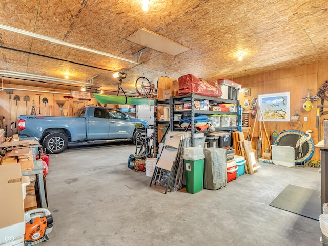 garage featuring a garage door opener and wood walls