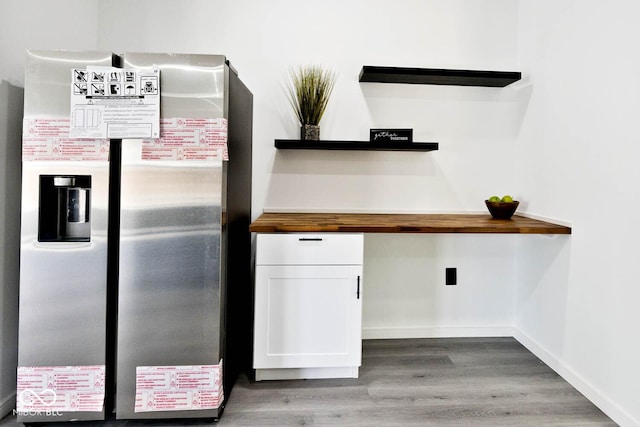 kitchen with wood counters, light hardwood / wood-style flooring, white cabinets, and stainless steel refrigerator with ice dispenser