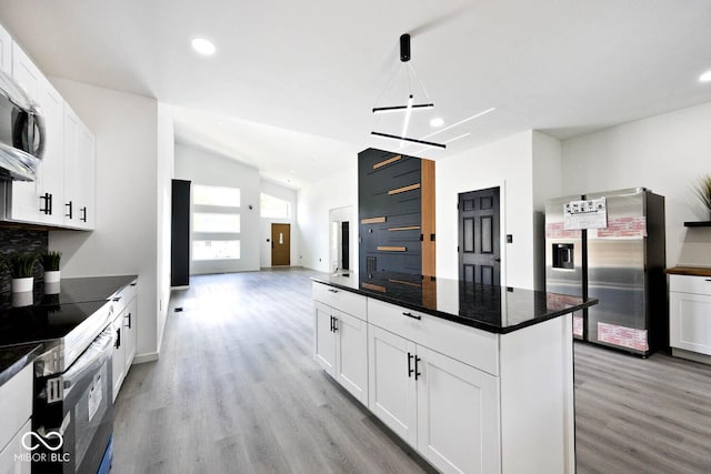 kitchen with white cabinetry, stainless steel appliances, light hardwood / wood-style floors, and a kitchen island