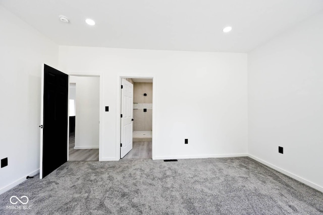 unfurnished bedroom with connected bathroom and light colored carpet