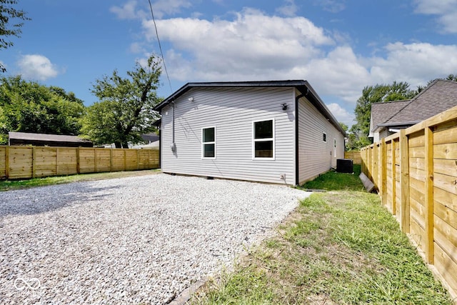 rear view of property with central AC and a yard