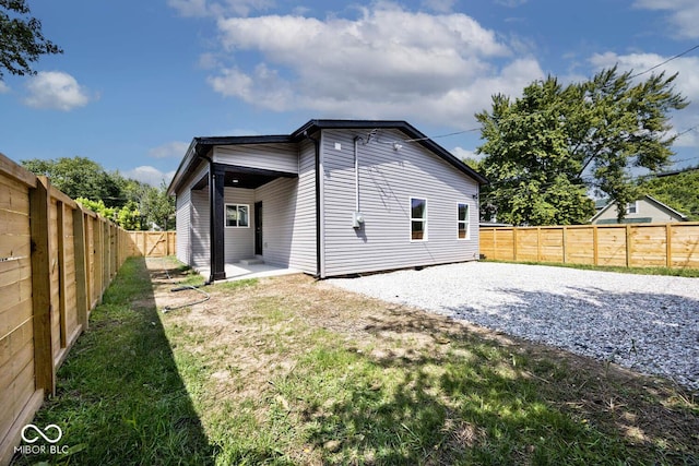 back of property with a yard and a patio