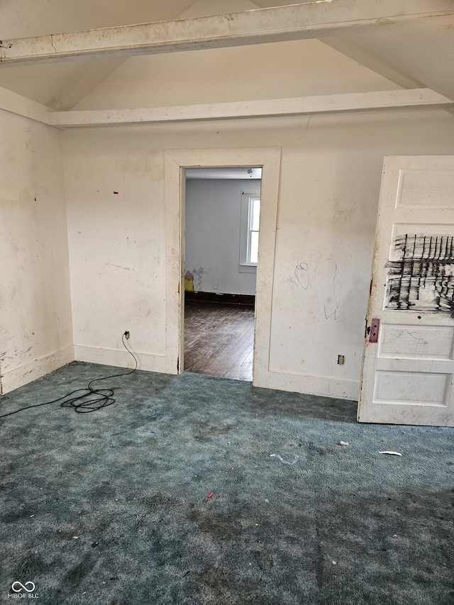 carpeted empty room with vaulted ceiling