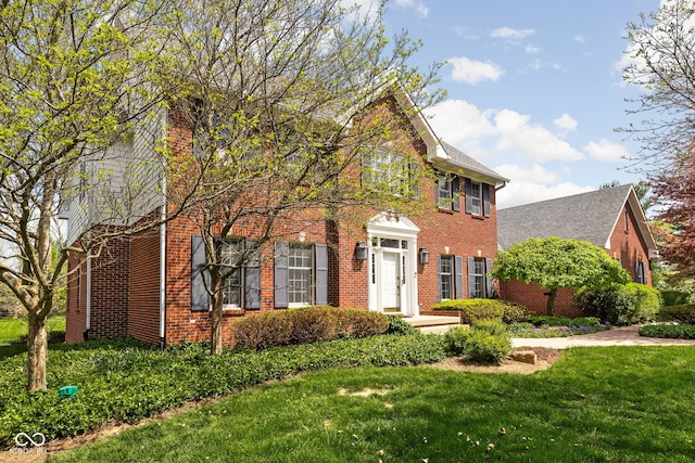 8552 E 550 S, Zionsville, IN 46077 - colonial home featuring a front lawn, brick siding, a chimney, and roof with shingles