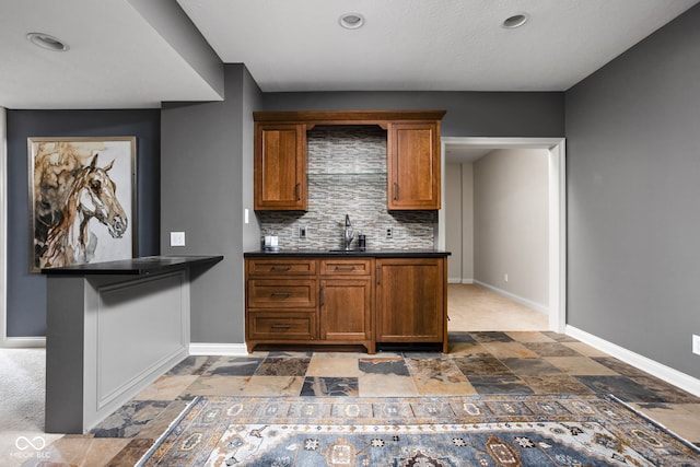 8552 E 550 S, Zionsville, IN 46077 - kitchen with dark stone finish floors, brown cabinets, decorative backsplash, dark countertops, and recessed lighting