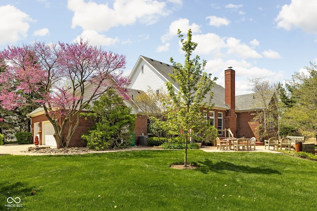 8552 E 550 S, Zionsville, IN 46077 - view of front of home with brick siding, a front lawn, driveway, a patio area, and a chimney