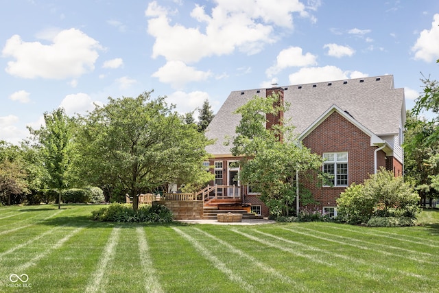8552 E 550 S, Zionsville, IN 46077 - rear view of house featuring a lawn, a wooden deck, a shingled roof, and brick siding