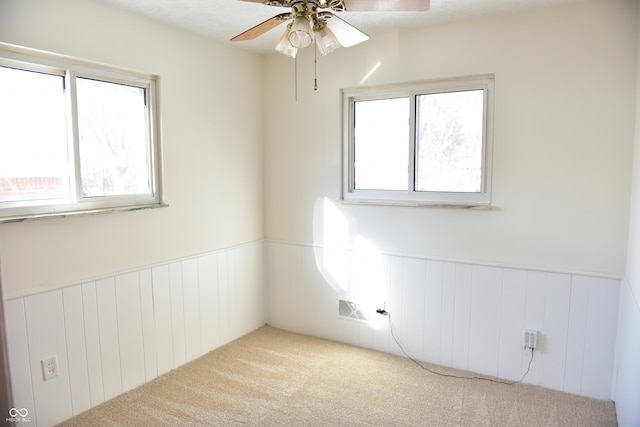 empty room featuring light carpet, plenty of natural light, and ceiling fan