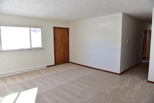 carpeted empty room featuring baseboard heating and a textured ceiling