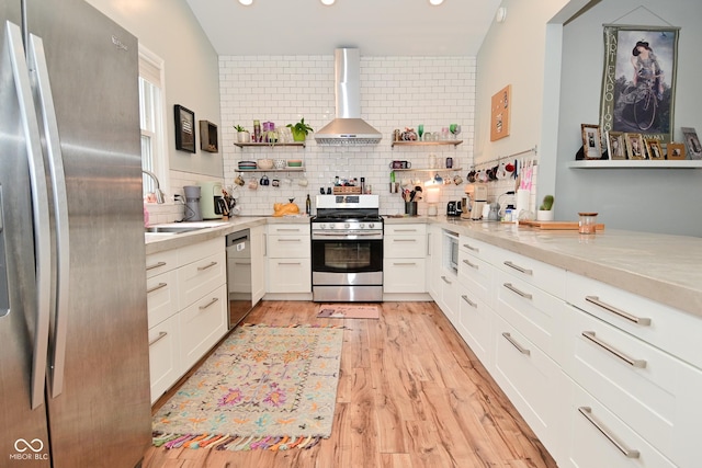 1719 Fletcher Ave, Indianapolis, IN 46203 - kitchen with light stone counters, wall chimney range hood, light wood-type flooring, stainless steel appliances, and white cabinets
