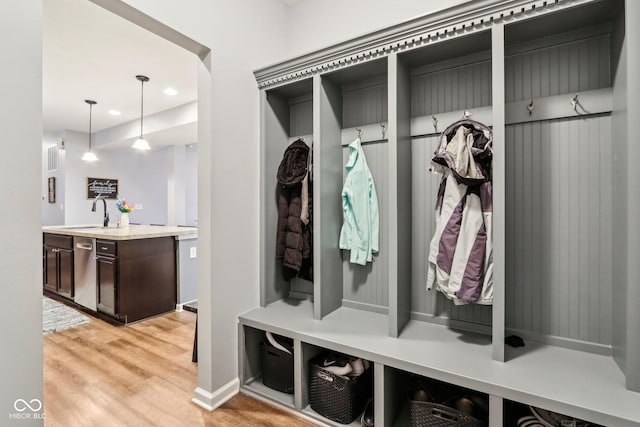 mudroom with sink and light hardwood / wood-style flooring