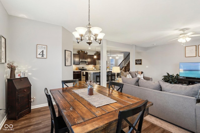 dining room featuring ceiling fan with notable chandelier and dark wood-type flooring