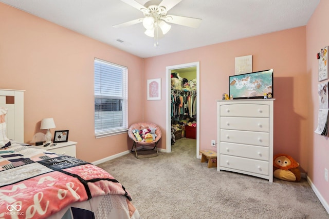 bedroom with ceiling fan, a walk in closet, carpet floors, and a closet