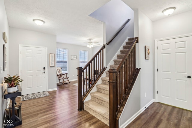 entrance foyer with dark wood-type flooring, ceiling fan, and a textured ceiling