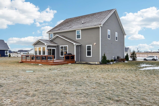 back of house featuring a lawn and a deck