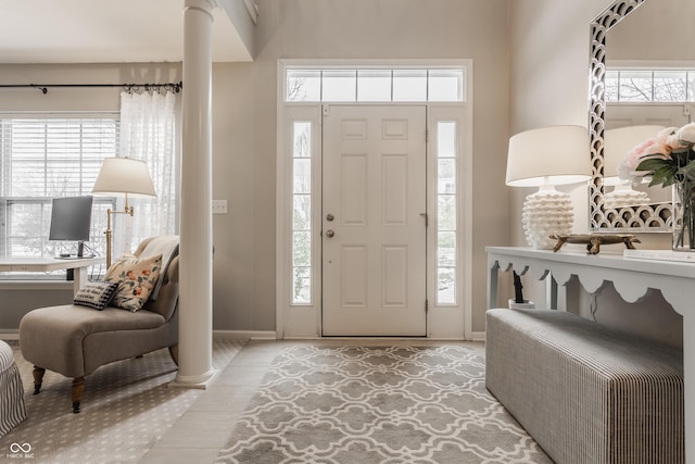 tiled foyer featuring decorative columns and a wealth of natural light