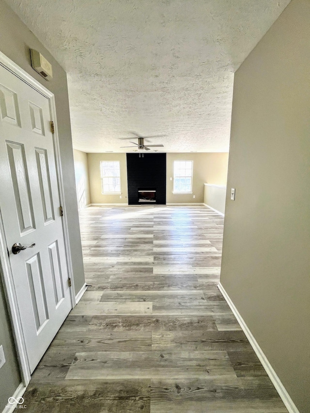 hallway featuring a textured ceiling and light hardwood / wood-style floors