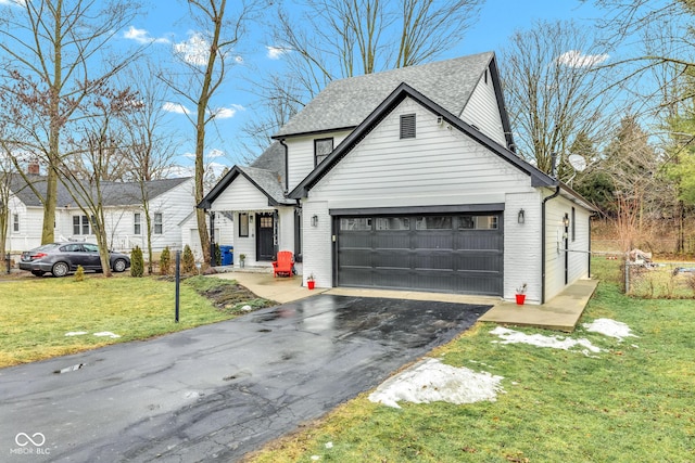 view of front of home with a garage and a front lawn