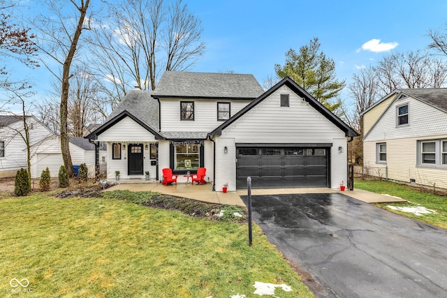 view of front of home featuring a garage, a patio area, and a front yard