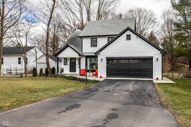 view of front of house with driveway, brick siding, a front yard, and fence