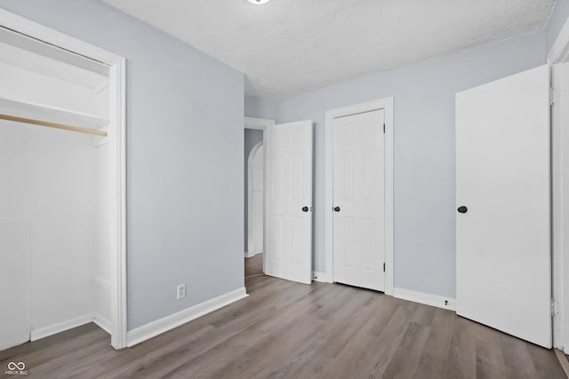 unfurnished bedroom featuring hardwood / wood-style floors and a textured ceiling