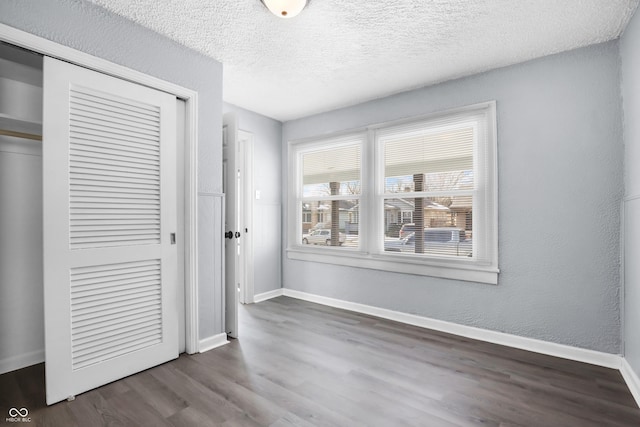 unfurnished bedroom with hardwood / wood-style flooring, a textured ceiling, and a closet