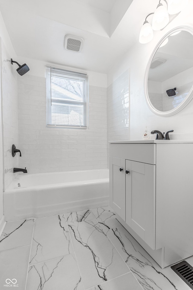 bathroom featuring tiled shower / bath and vanity