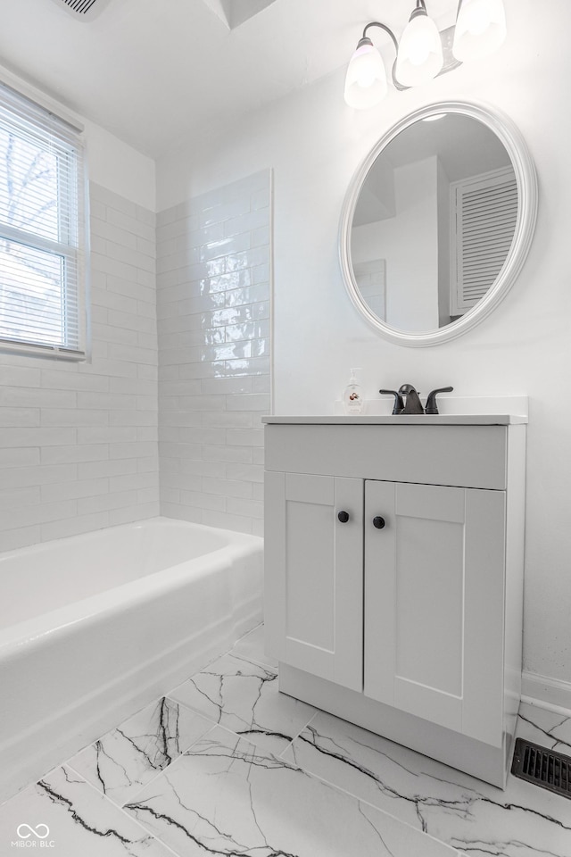 bathroom featuring a washtub, vanity, and an inviting chandelier