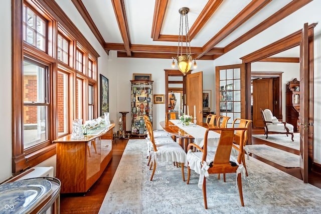 dining room with coffered ceiling, dark wood-type flooring, a notable chandelier, and beam ceiling