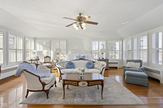 sunroom / solarium featuring lofted ceiling, radiator, and ceiling fan