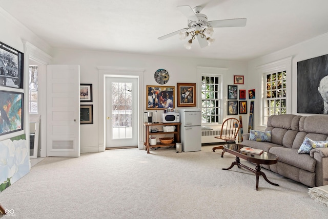 carpeted living room with ceiling fan and a healthy amount of sunlight