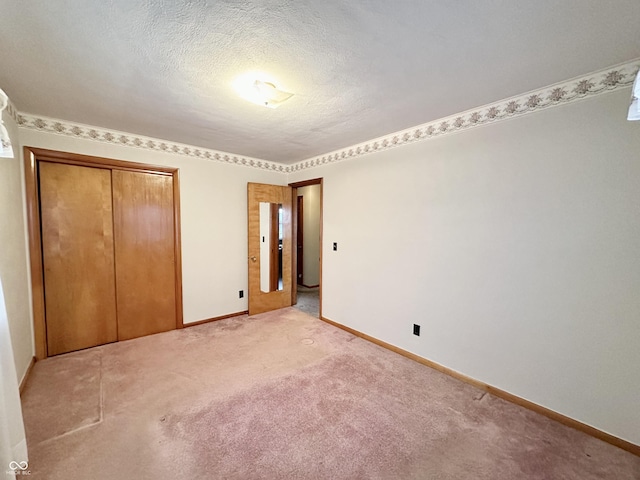 unfurnished bedroom featuring a closet, a textured ceiling, and carpet flooring