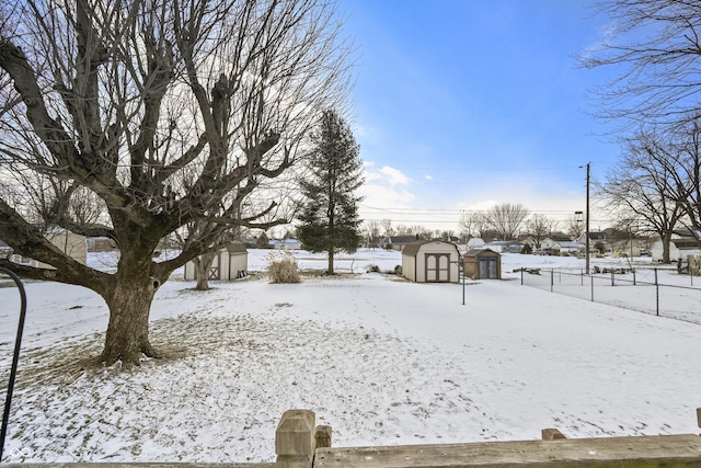 yard covered in snow with a shed