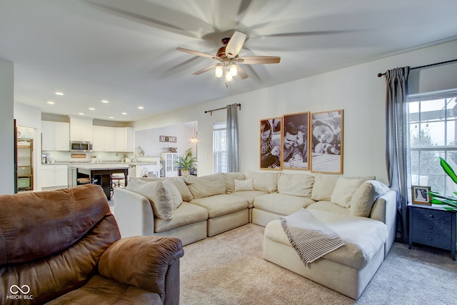 living room featuring light colored carpet and ceiling fan