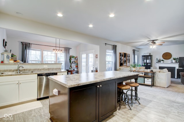 kitchen with french doors, sink, white cabinetry, hanging light fixtures, and dishwasher