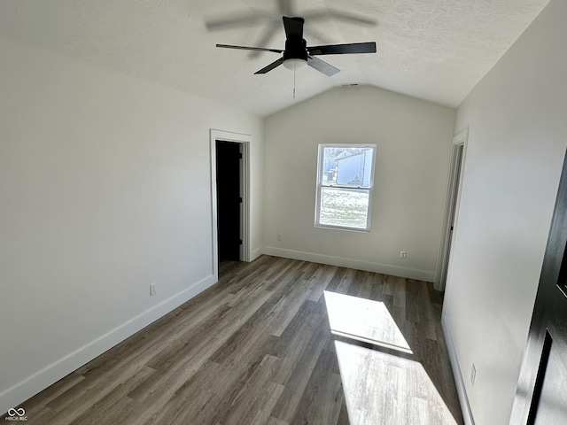 unfurnished bedroom featuring ceiling fan, lofted ceiling, a textured ceiling, and light wood-type flooring